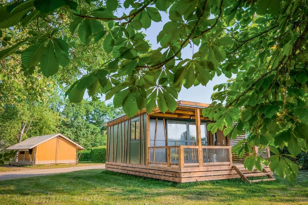 une petite maison au milieu d'une cour dans l'établissement Camping Onlycamp le Champ d'été, à Reyssouze