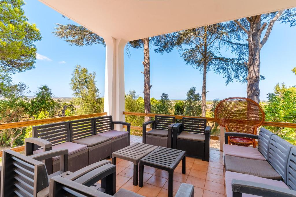 a deck with chairs and tables and trees at Villa Santa Anastasia in Matino