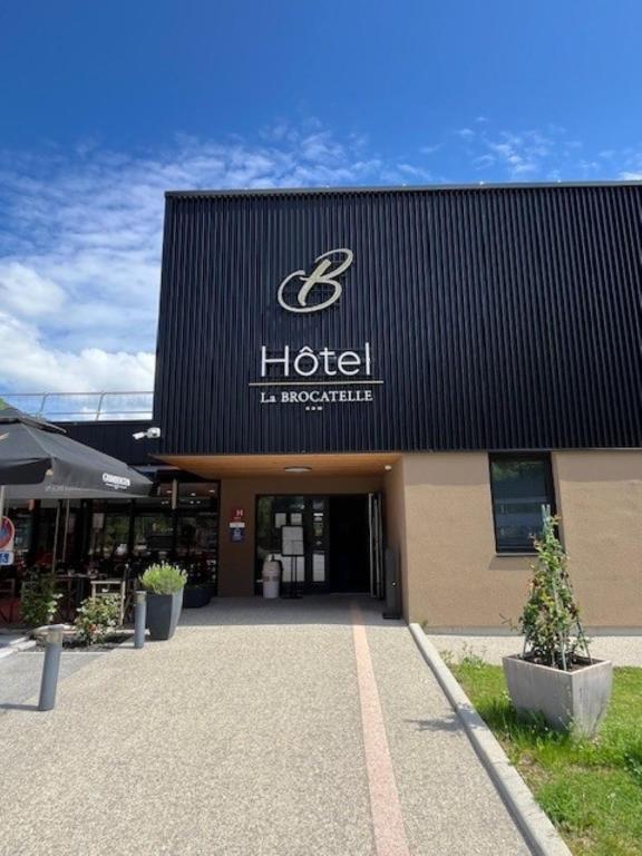 a hotel sign on the front of a building at Hôtel Restaurant AKENA Molinges - La Brocatelle in Saint-Claude