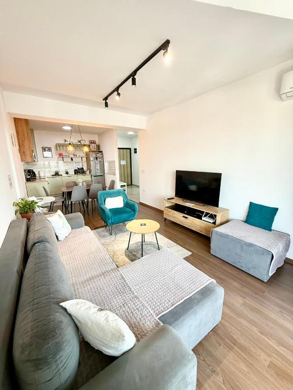 a living room with a couch and a tv at MML Apartment Skopje in Skopje