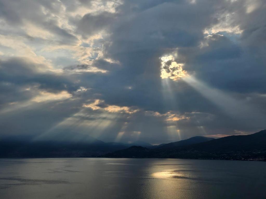 a cloudy sky with the sun shining through the clouds at Mid of Nature ' Bella Vista Lago Maggiore charmant mit traumhaften Seeblick, Terrasse und großen Garten in Ghiffa