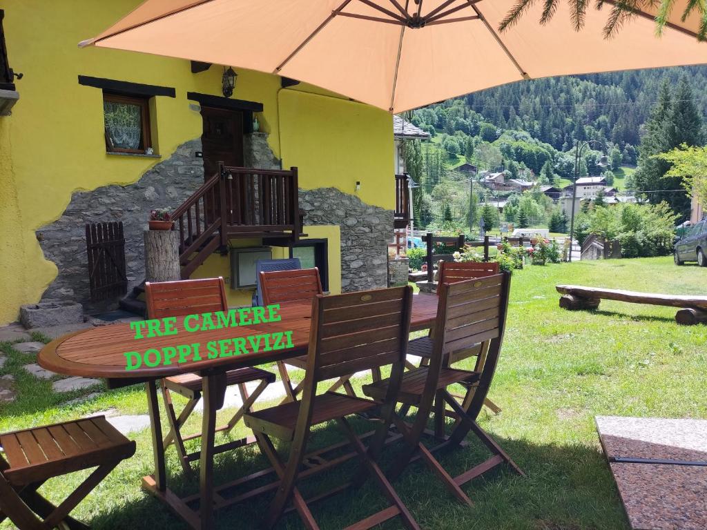a table and chairs with an umbrella in a yard at Maison du Soleil- CIR VDA Valtournenche n 0204 in Valtournenche