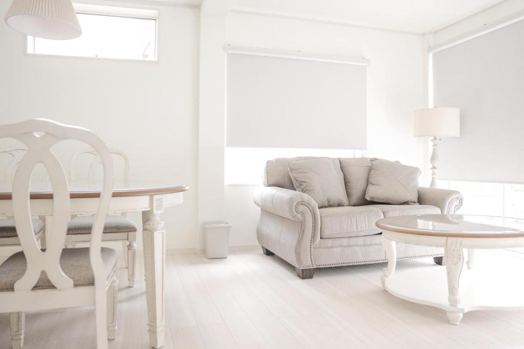 a white living room with a couch and a table at 静岡 伊豆高原 ペットと泊まれるプライベートヴィラ Tous les doudouトゥレ ドゥドゥ in Ito