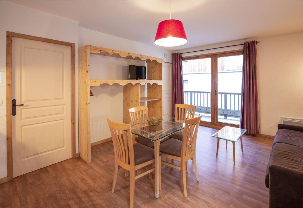 a dining room and living room with a table and chairs at Hameau 8 205 - SPA & PISCINE studio 4 pers in Orelle