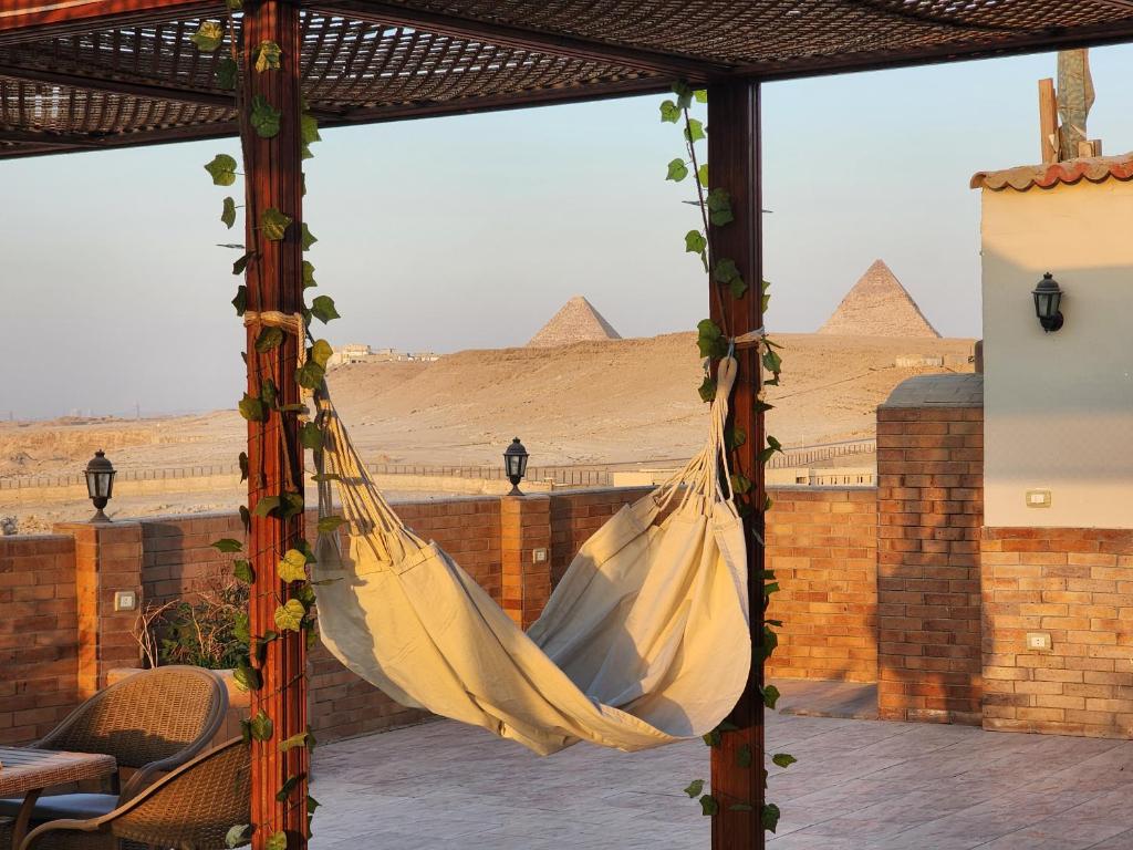 a hammock with a view of the pyramids at Private rooftop with jacuzzi and pyramids view in ‘Ezbet `Abd el-Ḥamîd