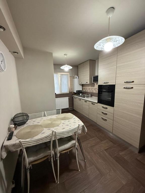 a kitchen with a table and chairs in a room at Apartament Craiova in Craiova