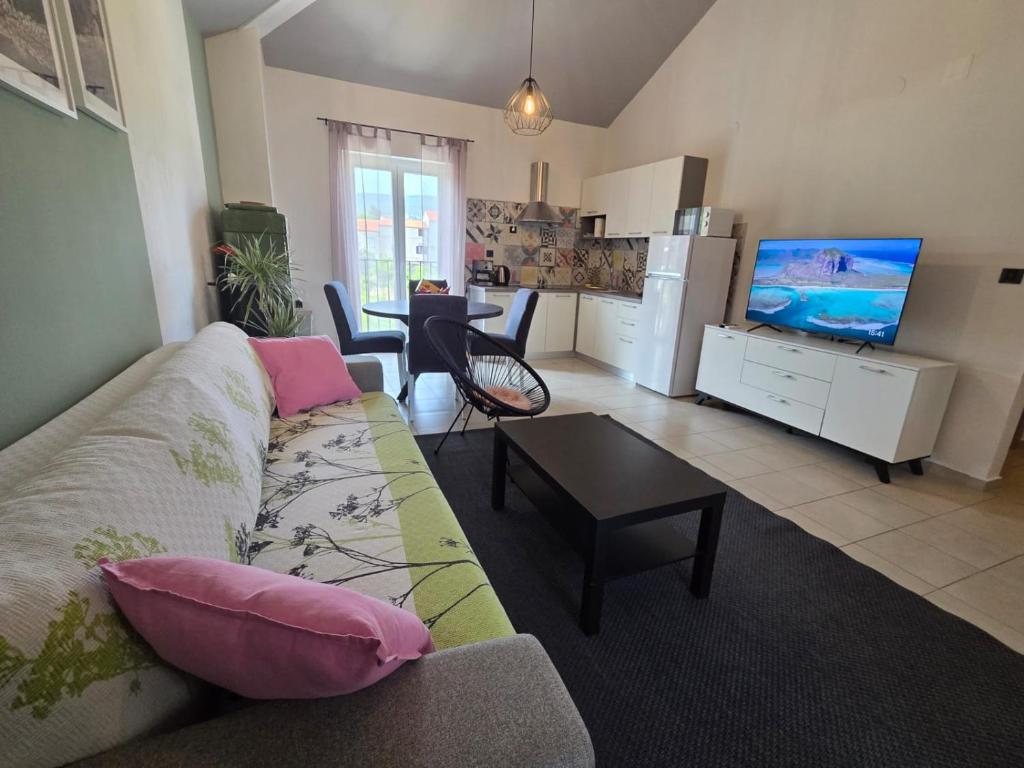 a living room with a couch and a tv at The Lovely Loft in Cres