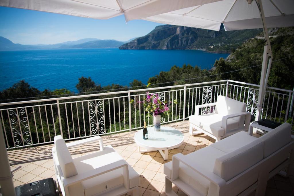 馬拉泰亞的住宿－Villa Caterina Affittacamere，阳台配有桌椅,享有水景。