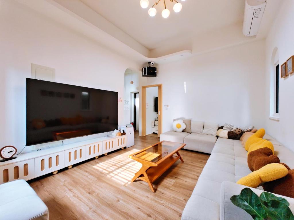 a living room with a large flat screen tv at There B&B in Jiaoxi