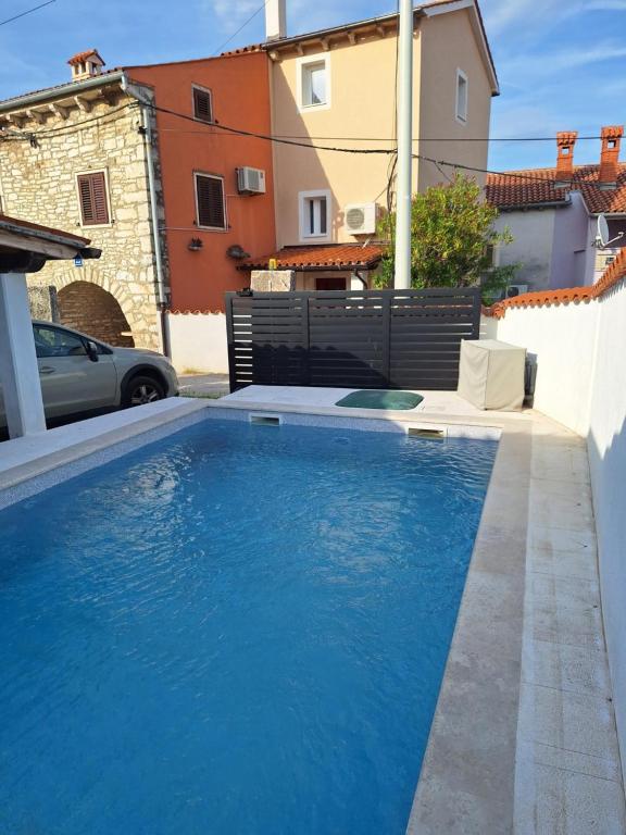 una grande piscina blu in un cortile con edifici di Blue Pool House Rakalj a Rakalj