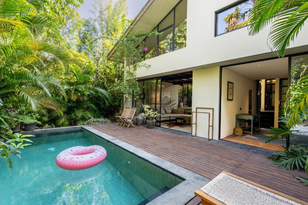 a house with a swimming pool and a house at Loft 7 Villa by Betterplace in Canggu
