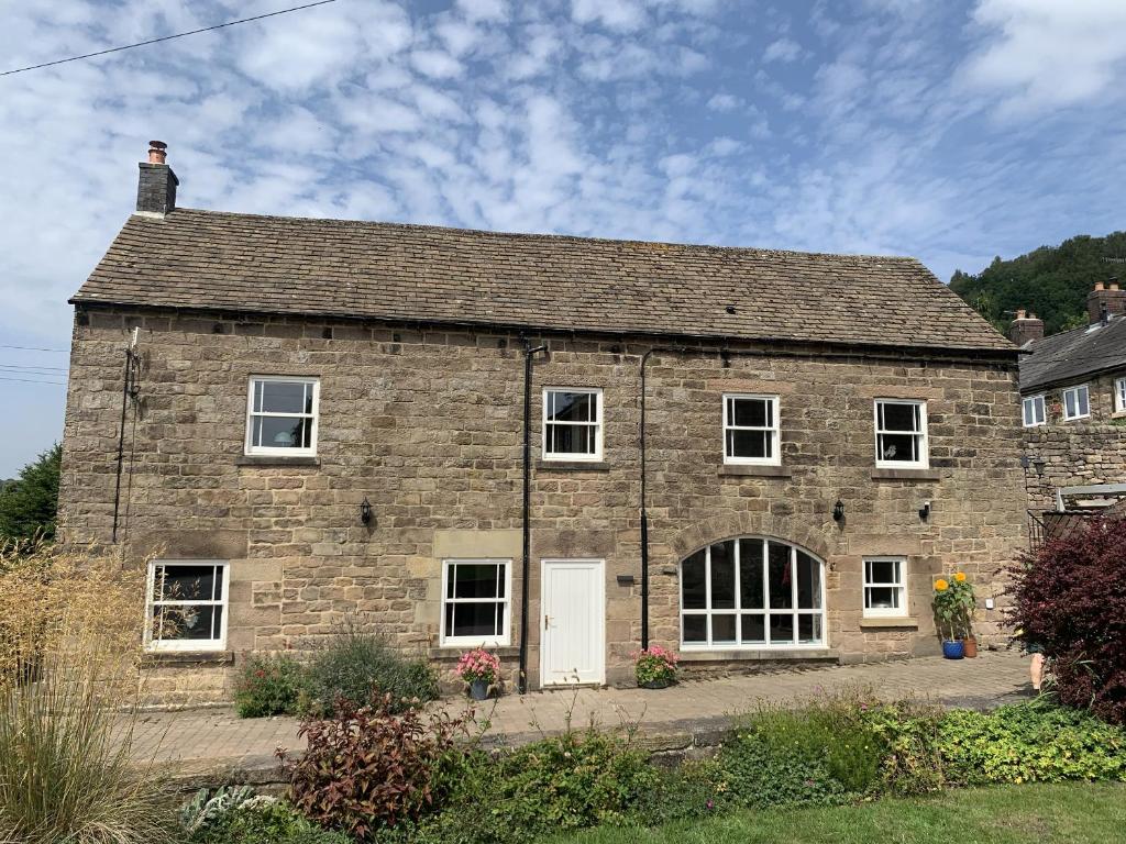 an old brick house with a white door at The Coach House in Matlock