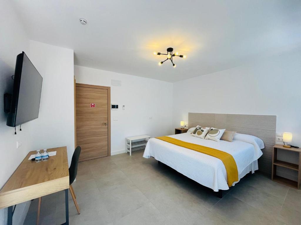 a bedroom with a bed and a desk and a television at HOTEL MUSEO Lucainena in Lucainena de las Torres