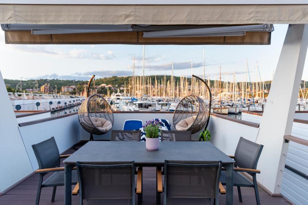 un tavolo e sedie su un balcone con porto turistico di Floating Seahouse Ocean Beauty a Portoroz