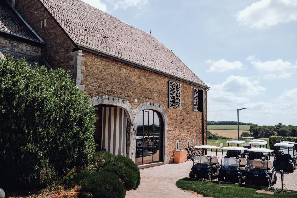 a brick building with tables and chairs in front of it at Hôtel & Restaurant Five Nations in Durbuy