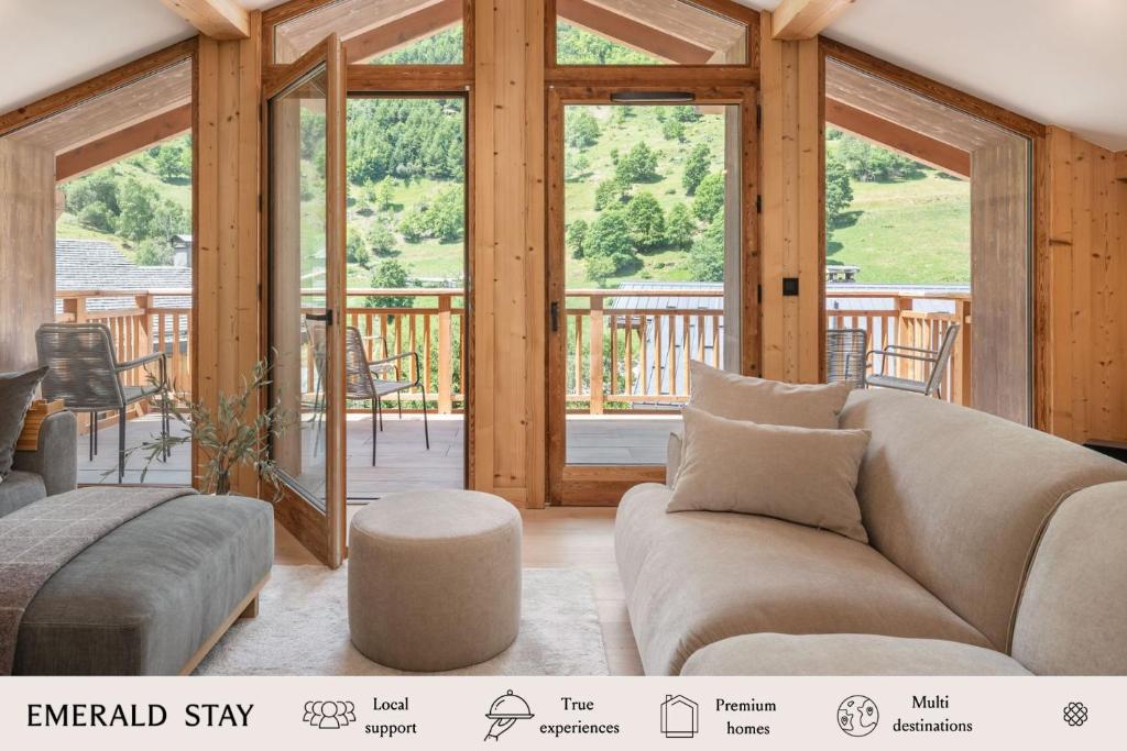 un soggiorno con un divano e una grande finestra di Apartment La Chouette Les Belleville - by EMERALD STAY a Levassaix