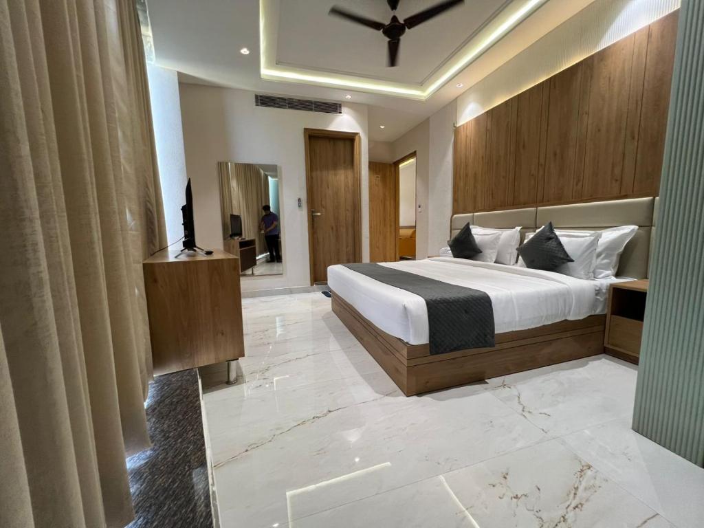 Un dormitorio con una cama grande y un espejo. en Hotel Vevanta, en Alwar