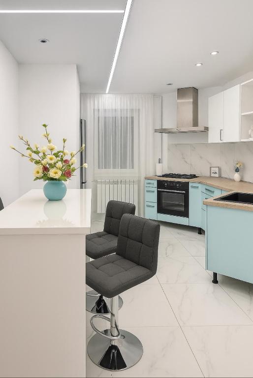 a kitchen with a chair and a table with a vase of flowers at House Elisa in Sighetu Marmaţiei