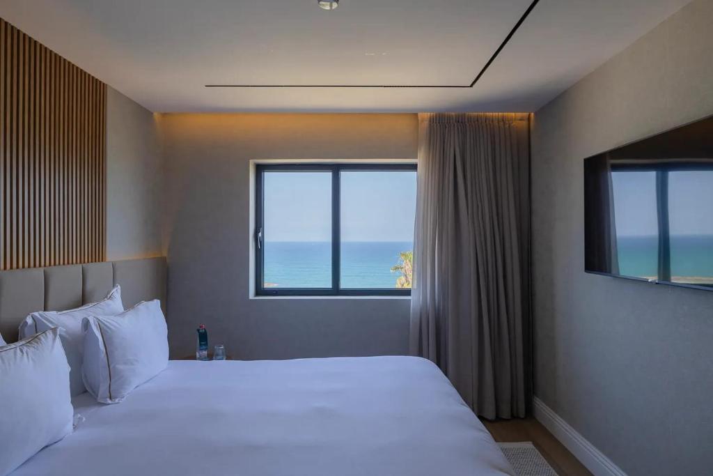内坦亚Seanergy Boutique & Spa Hotel的一间带床的卧室，可欣赏海景