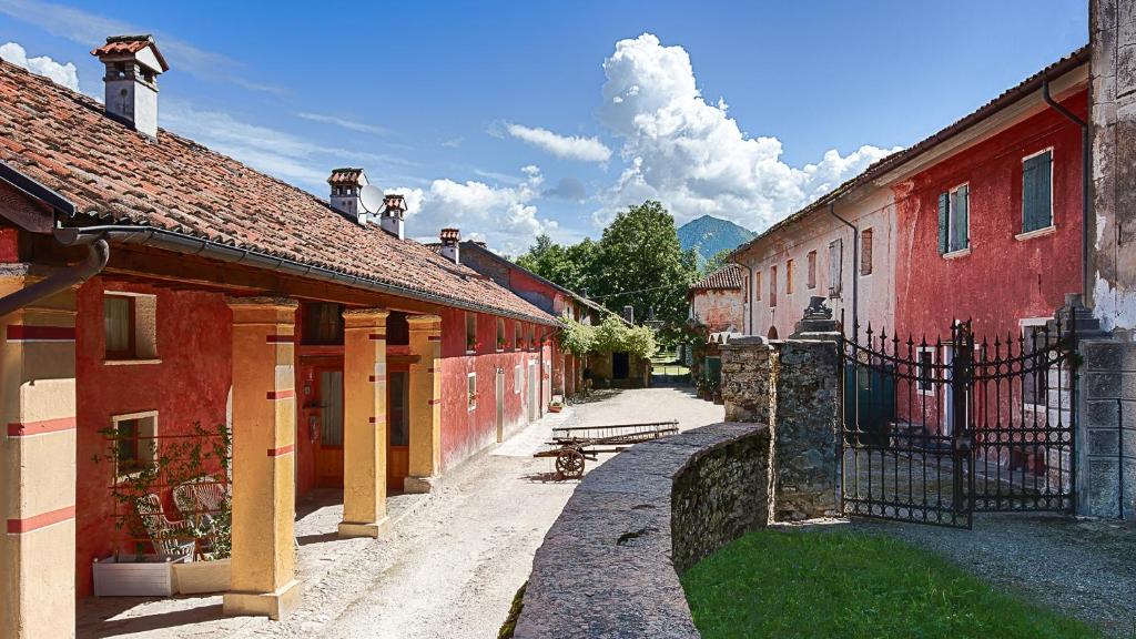 Agriturismo Casa de Bertoldi في بيلونو: شارع فيه مباني حمراء ومقعد في مدينة