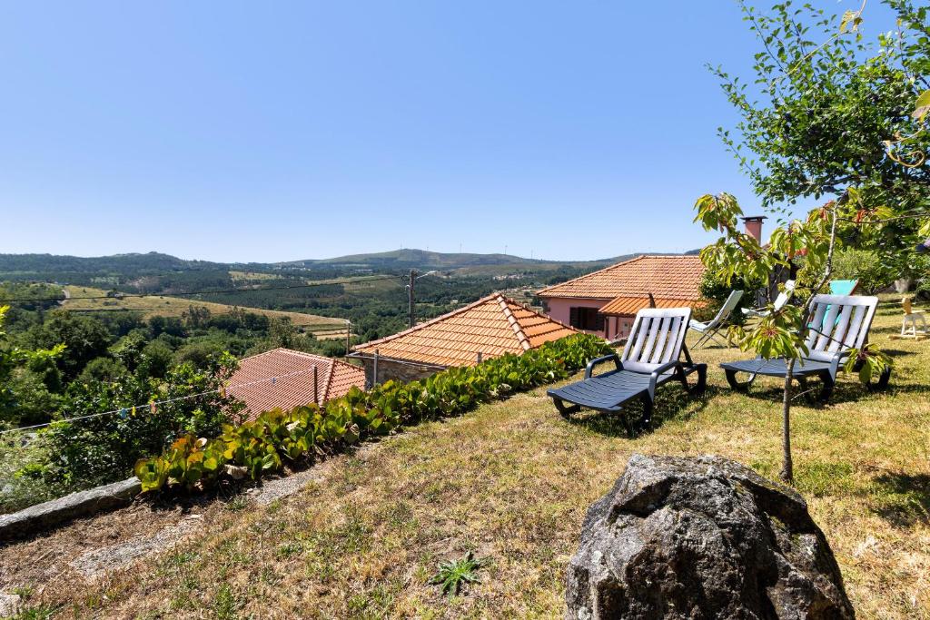 dos sillas sentadas en la cima de una colina en Quinta Natureza de Coura, en Paredes de Coura