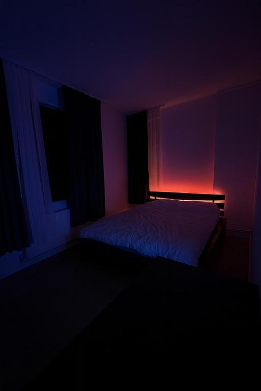 a dark room with a bed and a red light at TS House in Cluj-Napoca