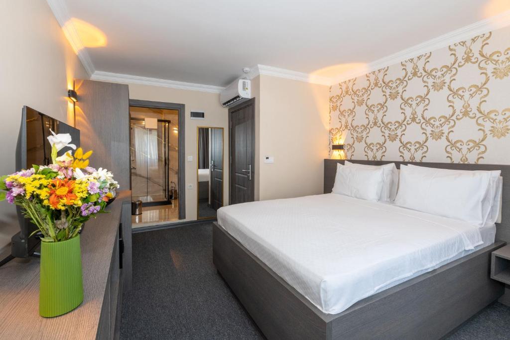 a hotel room with a bed and a vase of flowers at Istanbul By Rich Hotel in Istanbul