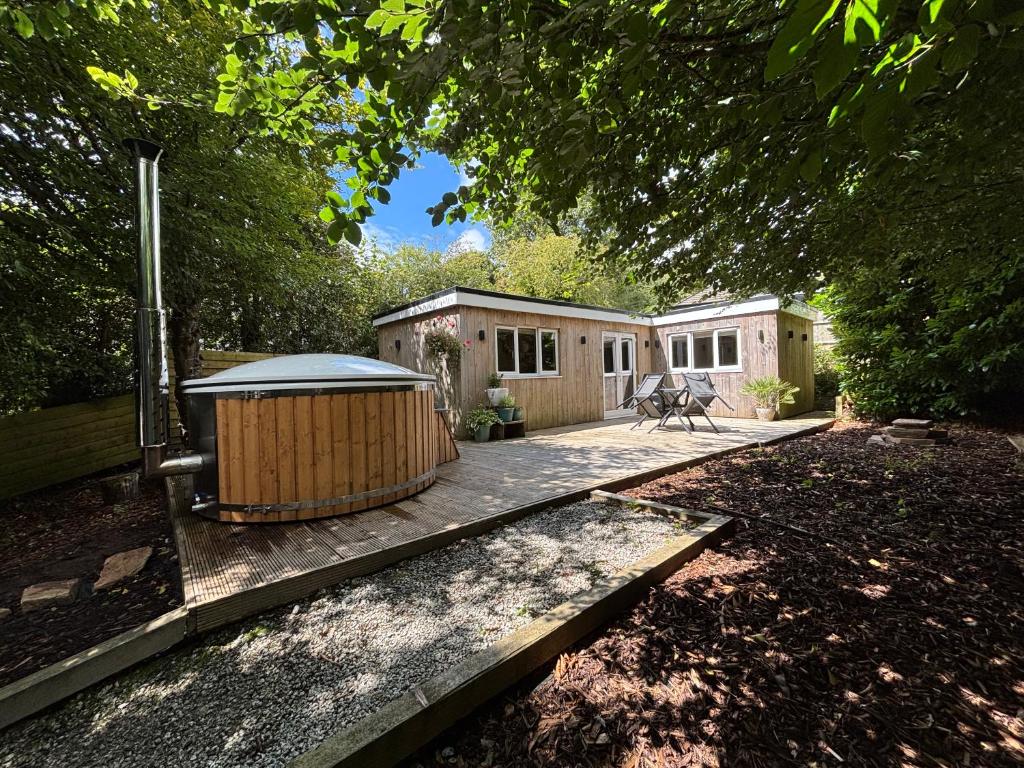 une petite cabine avec terrasse dans une cour dans l'établissement Cornish wooden cabin & wood fired hot tub, à Gwennap