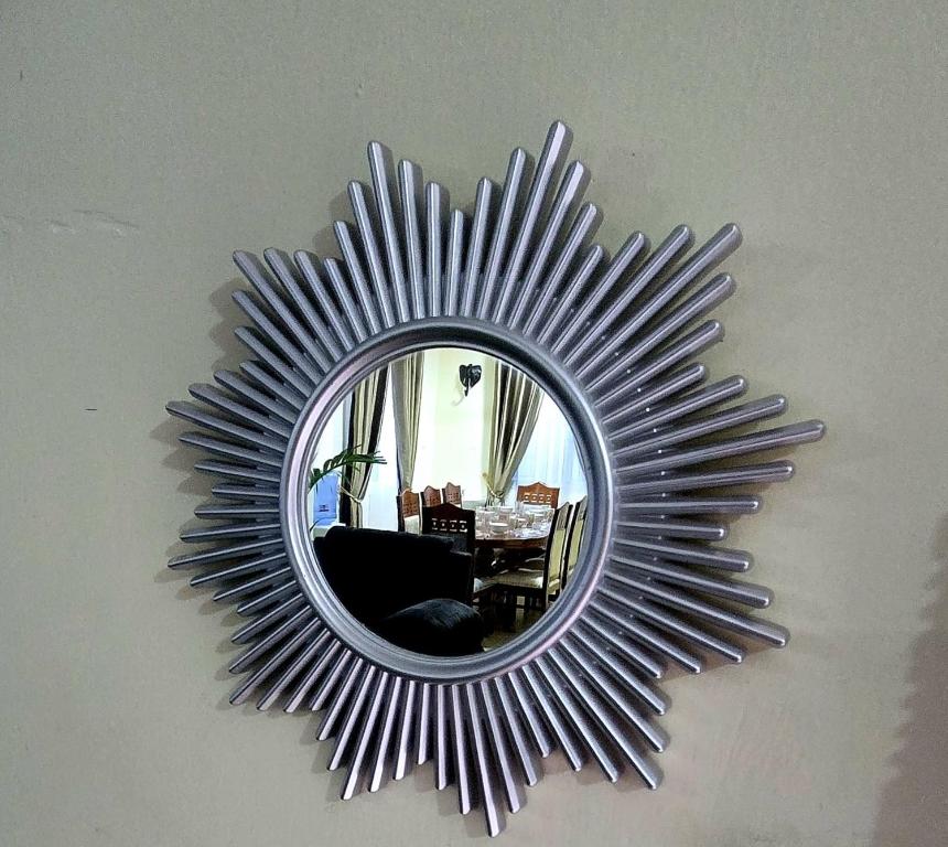 a mirror on a wall with a chair and a table at ROYAL MTWAPA House in Mtwapa