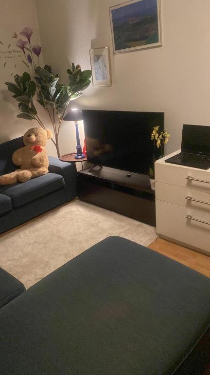 a living room with a teddy bear sitting on a couch at 2 bedroom apartment in Lijordet