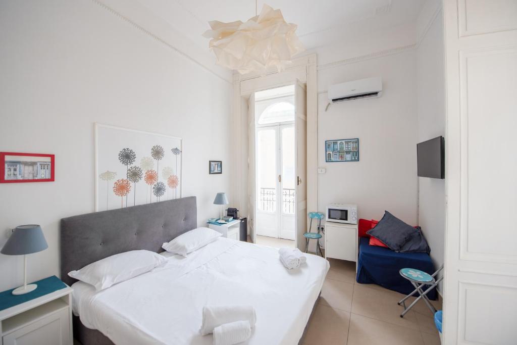 a bedroom with a white bed and a blue couch at A casa di Giulia By Dimorra in Naples