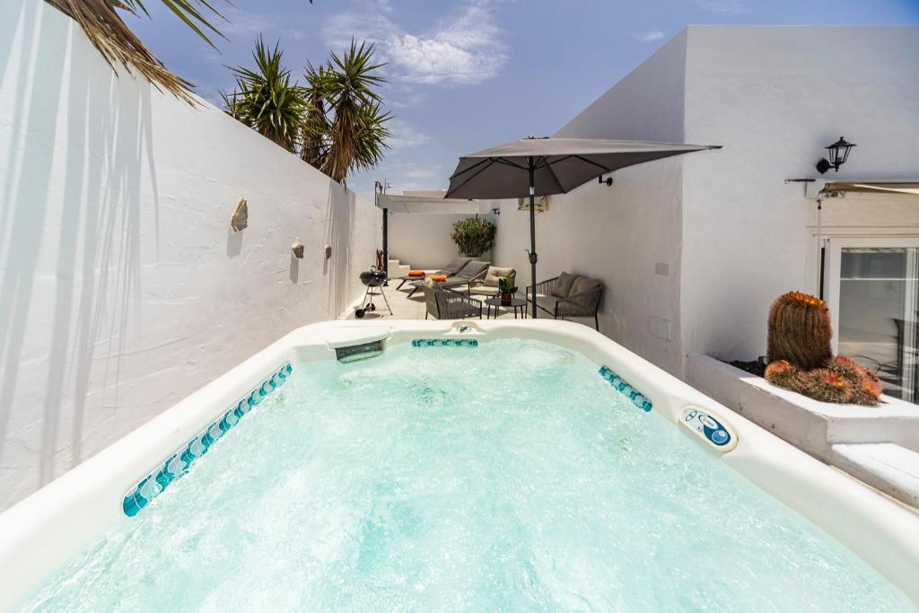 a jacuzzi tub in a room with an umbrella at Luxury Beach La Concha Playa Honda in Playa Honda