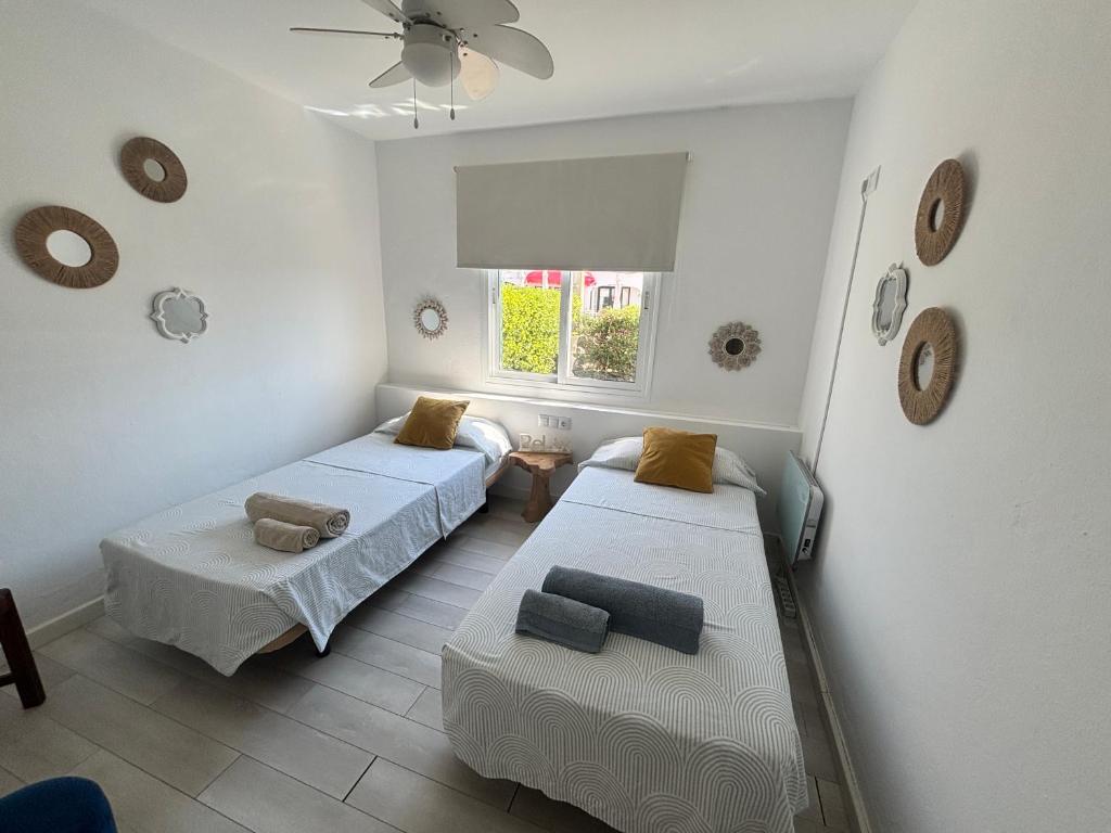 Habitación con 2 camas, sofá y ventana en Apartamento con jardín privado en Menorca, en Cala'n Porter