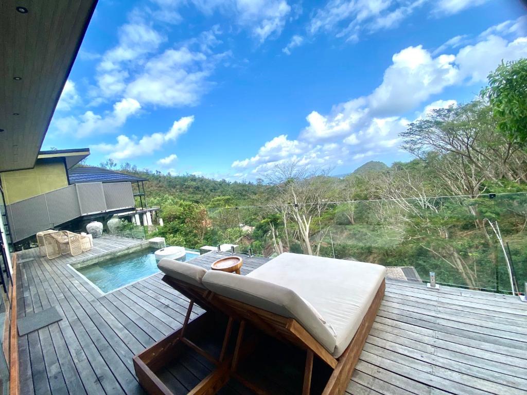 una cama en una terraza junto a una piscina en COVE VILLAS Mandalika, en Kuta Lombok