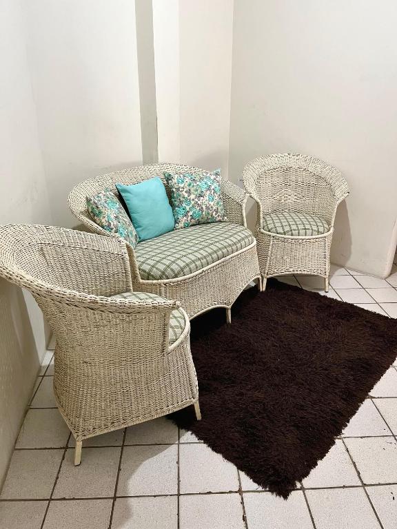 a room with two wicker chairs and a blue pillow at 03 Apartamento Asa Branca in Caruaru