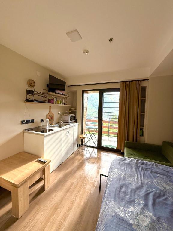 a room with a kitchen and a living room at Mountain View Apartment Near Ski Slopes Gudauri in Kʼumlistsʼikhe