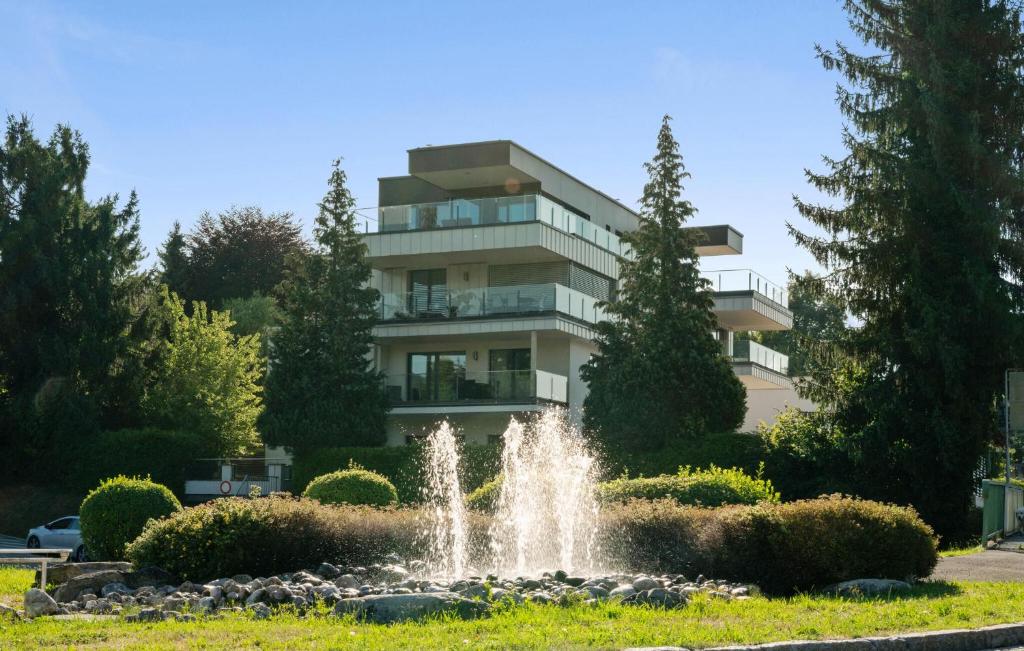a fountain in a park in front of a building at Ferienwohnung Pörtschach 90M² in Pörtschach am Wörthersee