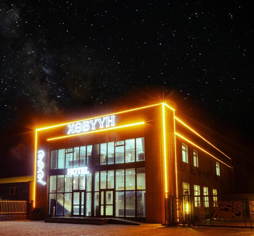 DalandzadgadKhovuun hotel的一座建筑,在晚上前方有标志