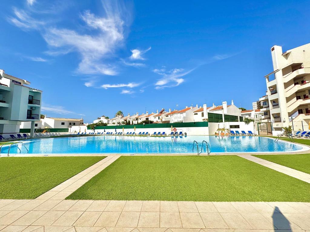 a large swimming pool with chairs and a building at Albufeira Skylight 2 by Homing in Vale de Pedras
