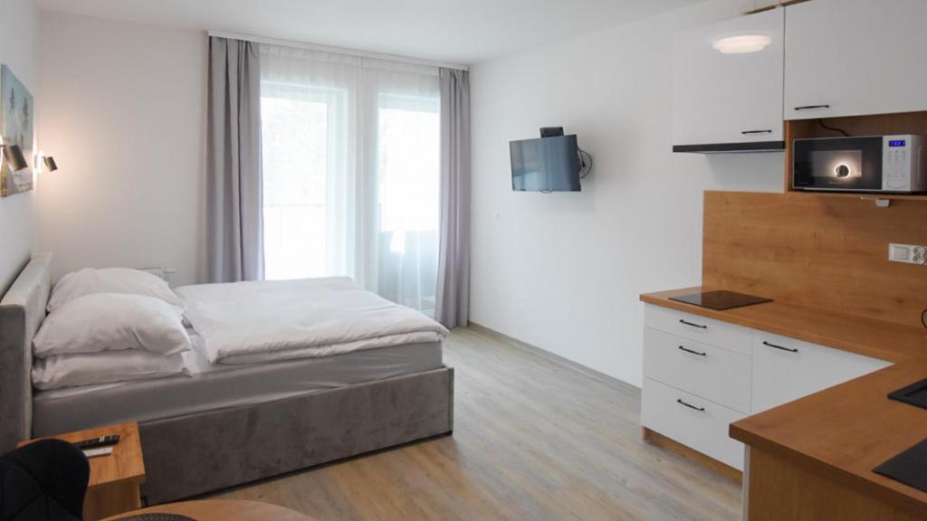 a small bedroom with a bed and a tv at VacationClub - Lotnicza 1L Apartament 44 in Sianozety
