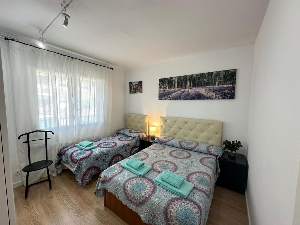 a bedroom with two beds and a window at Rooms Borrells in Barcelona