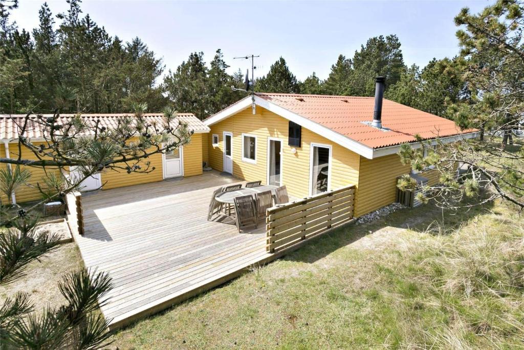 a wooden deck in front of a yellow house at 560-Thisted-Klitrosevej-60 in Thisted
