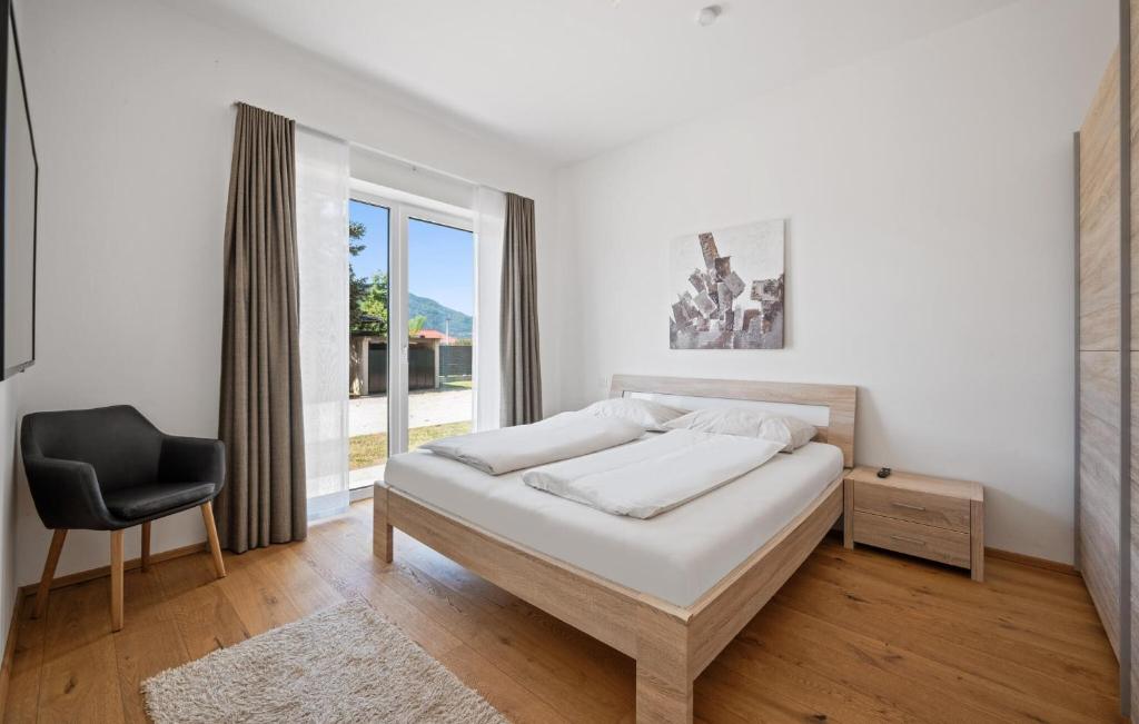 Un dormitorio con una cama y una silla y una ventana. en Ferienwohnung 52M², en Pörtschach am Wörthersee