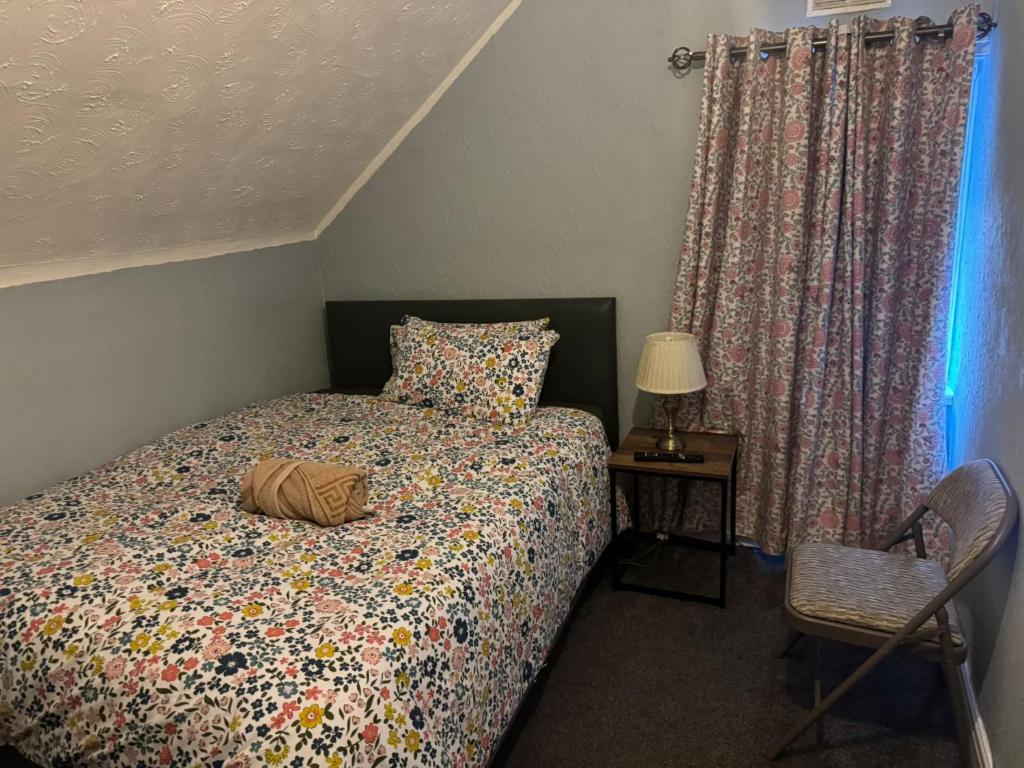 Giường trong phòng chung tại Woodville Lodge Leeds - A Cosy Guest House with Self Service Residents Kitchen