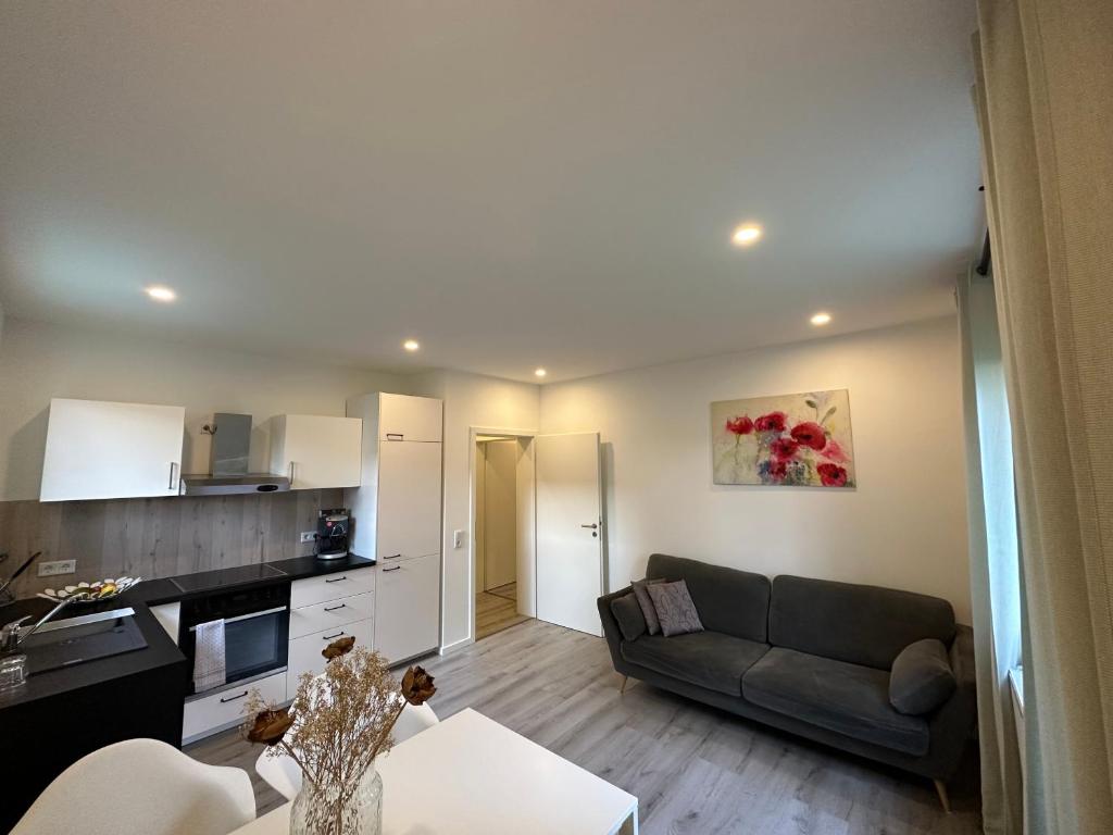 a living room with a couch and a kitchen at Geräumiges Apartment nähe Starlight express & Stadtzentrum in Bochum