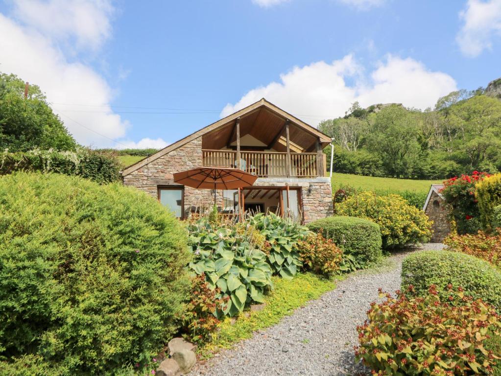 a stone house with a balcony and a walkway at Dan Castell Cottage in Llandeilo