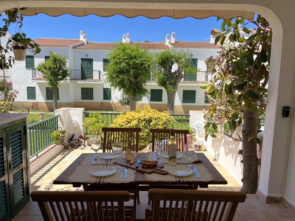 a table and chairs on a patio with a building at COACH HOUSE by SOM Menorca in Son Parc
