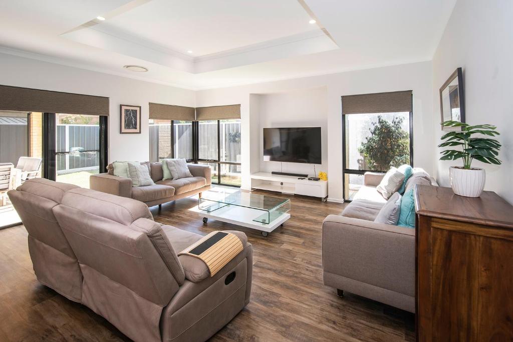 a living room with two couches and a tv at Tidal Wave Hideaway in Broadwater