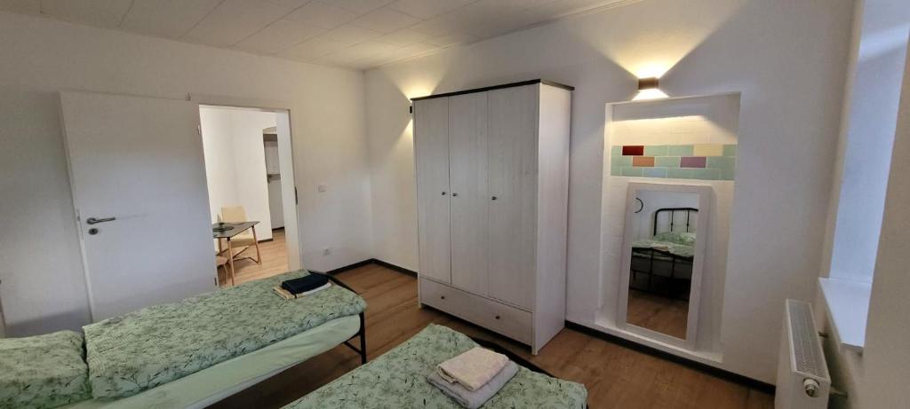 a room with two beds and a cabinet at Seyfarthrooms - Monteurwohnung Großröhrsdorf 4 - zentrale Lage, gute Anbindung, ideal für 2 Personen in Großröhrsdorf