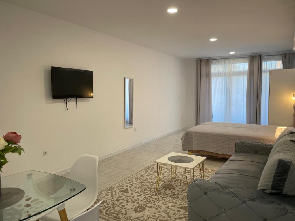 a room with a bed and a couch and a table at Apartmani Covic Medjugorje in Međugorje
